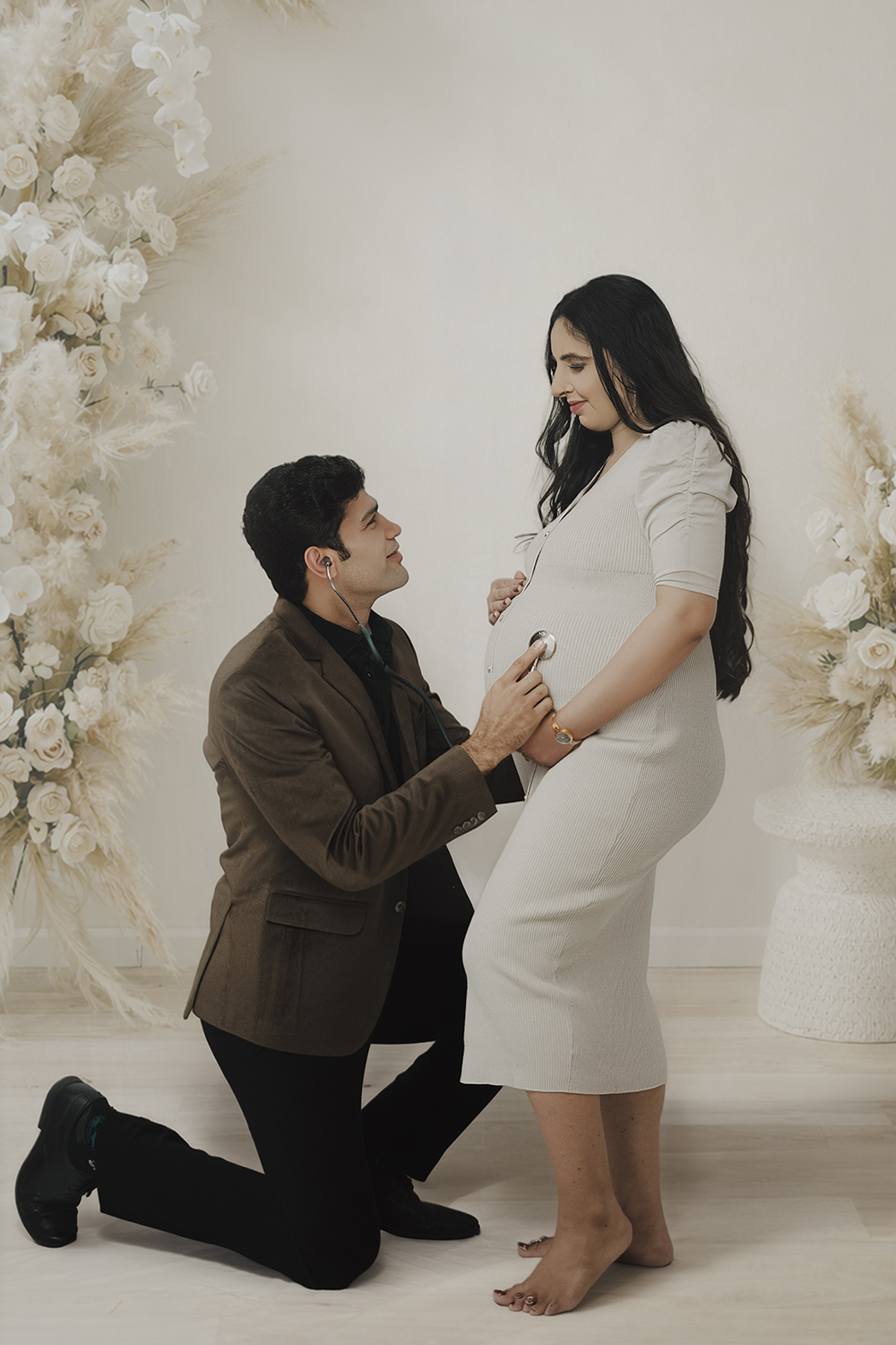 Father listening to an expecting mother's baby bump
